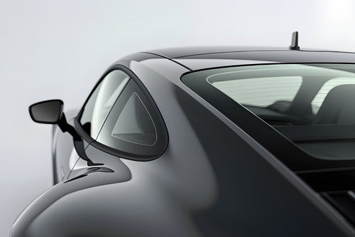 Close-up of a car's side mirror and window on a light gray background